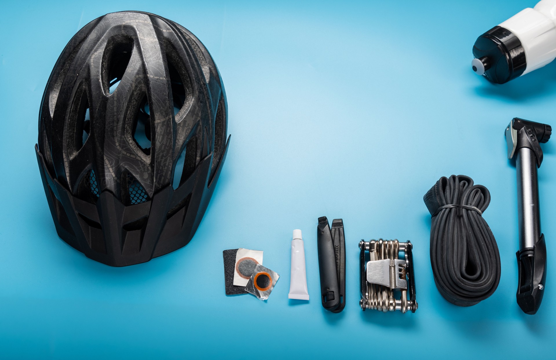 Minimal repair kit for a bike rider. Cycling helmet and bicycle repair parts. Velo composition. Copy Space.